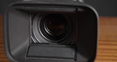 Here is a close up view of a camera lens situated on a wooden table video