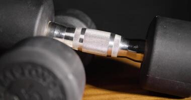 Closeups of dumbbells on a rustic table highlight their design, durability video