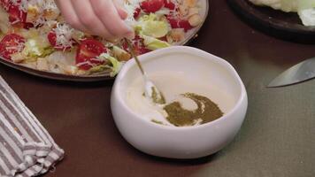 Chef added Provencal herbs to sour cream sauce, which was mixed with mayonnaise and garlic, to create delicious and exquisite delicacy. seasoning gave salad dressing unique taste. video
