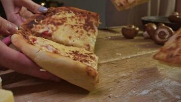 Each friend takes large slice of delicious, freshly prepared hot pizza, with several different types of cheese and tomatoes. video