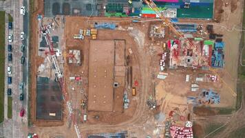 Construction site with cranes and foundations under construction, top view video