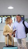 vertical Senior couple checking flight information at the airport video