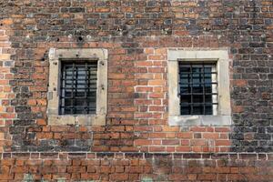 Old brick wall with metal bars on windows. Background. Poland, Wroclaw photo
