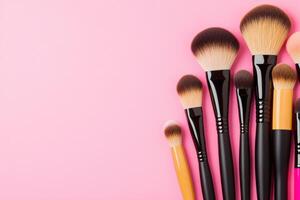 A collection of various makeup brushes on a pink backdrop, perfect for beauty and cosmetic themed designs. photo