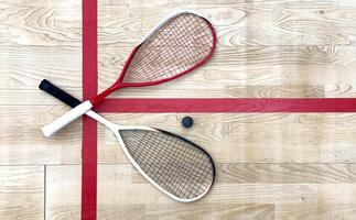 Sports, above and racket on squash court for competition, challenge and training center. Exercise, interior and empty room with top view of wooden floor of gymnasium for games, fitness club and gear photo