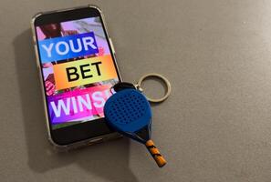 padel racket and smartphone with sports betting photo