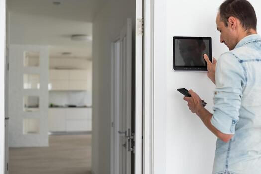 automation, internet of things and technology concept - thinking man looking at tablet pc computer at smart home photo