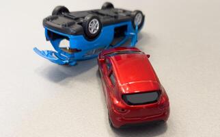 Two mini toy car crash on white background, incident, car traffic accident. Top view photo