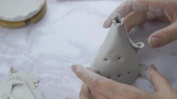 Woman forms wigwam of white clay with hands. Other mud objects on the marble table. Craft of sculptor. The concept of handmade. Material for manufacture of ceramic products. video