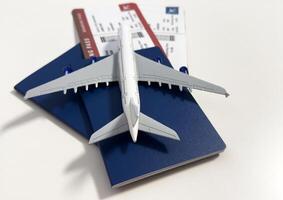 Toy airplane and passport with tickets on gray background, top view photo
