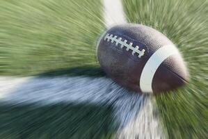 On a grass field there is an american football ball photo