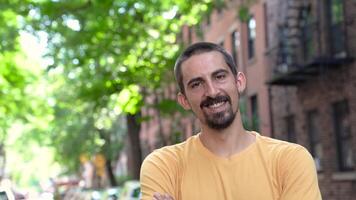 A cheerful man smiling happily outdoors in a vibrant urban environment during daylight hours video
