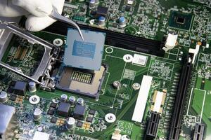 technician is installing the CPU onto the motherboard. photo