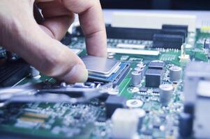 technician is installing the CPU onto the motherboard photo