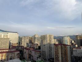 Cityscape of Batumi from high floor overlooking old district. Large residential area with tall houses and mountains in background in Georgia. Urban development with residential buildings photo