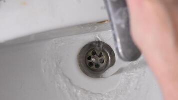 Close-up of a hand turning on a faucet and water pouring into a sink, then the person turning off the faucet video