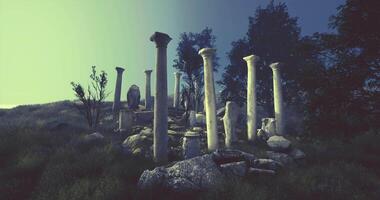 Ruins of ancient columns surrounded by nature at dusk in a serene landscape video