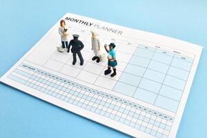 Concept of four-day work week. Printed calendar for a 4 day working week. Miniature Workers on Planner photo