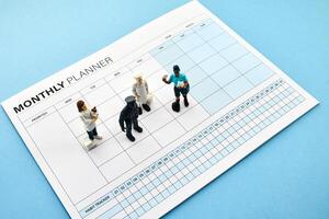 Concept of four-day work week. Printed calendar for a 4 day working week. Mini Figures on Planner photo