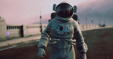 Astronaut walks on an empty road with an unusual background during dusk video