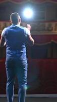 Performer speaks in front of beautiful richly decorated theater hall. Rows of red chairs in theater hall. Big empty theater with one person on stage. Vertical video