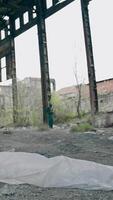 Abandoned building with garbage inside. Scientist in protective uniform in destroyed building. Biological attack. Vertical video