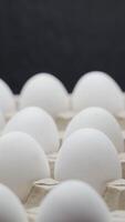 Eggs are stacked in a tray. Crates of fresh eggs at a poultry farm. Vertical video