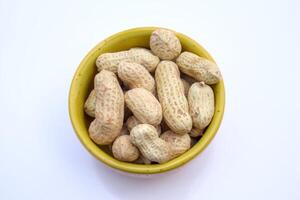 Peanuts, Groundnuts, Goobers in a bowl, Top View, Isolated, White Background photo