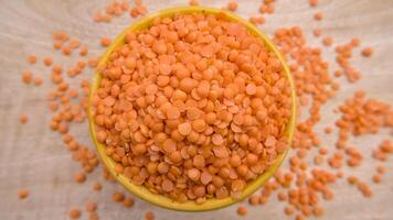 Red Lentils Masoor Dal Split and Dehusked in a Yellow Bowl - Rustic Close-Up Top View Flat Lay photo