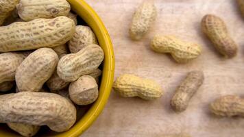 Peanuts in Bowl Top View Close-Up Flat Lay Shot on Wooden Background photo