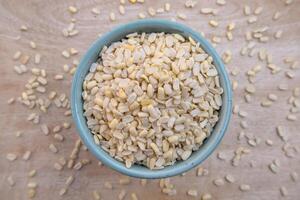 Flat Lay of Split Dehusked Black Gram, Matpe Beans White Lentils in a Blue Bowl, Top View photo