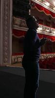 Actor during the rehearsal in large theater. Man performing on stage in front of empty auditorium. Consequences of pandemic. Vertical video