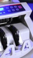 Modern electronic machine. Machine counter automatically calculates a large amount of dollar banknotes. Top view. Business accounting. Vertical video