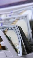 Zählen hundert von Dollar Rechnungen im Bank. finanziell Betrieb auf ein modern elektronisch Kasse Zählen Maschine. automatisch Ausrüstung zum Zählen Papier Geld. Vertikale video