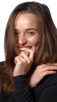 charming model is smiling and posing on a white background in the studio. Close-up Vertical video