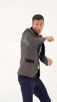 a man in a suit skillfully is copying the movements of a boxer during a fight in the studio. Parody from actor Vertical video