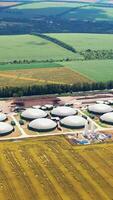 New factory among beautiful nature. Plant for biogas production on fields. Modern complex is equipped with its own biogas. Aerial view. Vertical video