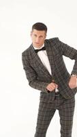 an adult man in a plaid jacket is making funny movements with his hands and body with with different facial expressions in the light studio Vertical video