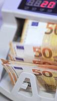 électronique calculs de euros. automatique équipement pour compte papier argent. cinquante euro billets de banque dans une moderne compte machine. verticale video