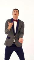 a man in a gray and blue colours of suit is juggling as a clown in the studio. Parody of a funny clown in a circus Vertical video