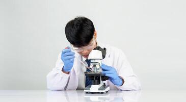 Asian male student scientist in reagent mixing laboratory In a science research laboratory with test tubes of various sizes and microscopes. on the table in laboratory chemistry lab white background photo