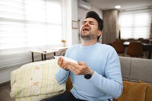 Sick man sneezing all day at home photo