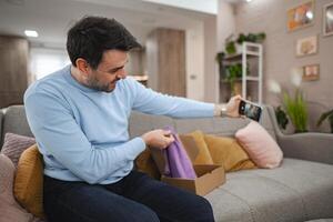 Grateful men talking on a call while unboxing a gift photo