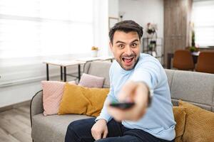 Man Sitting on Couch Holding Remote Control photo