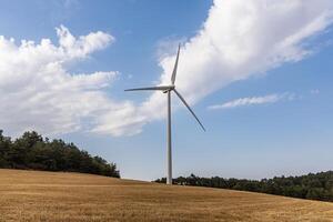 One white wind generator produces alternative energy by wind on the fields in Europe in Spain photo