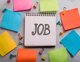 Top View of Job Written Note with Colorful Sticky Notes on Light Background photo