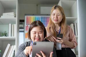 Diverse graphic design team collaborating on a tablet in a creative workspace. photo