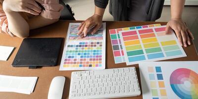 Graphic design team analyzing color palettes and materials in a collaborative workspace. photo