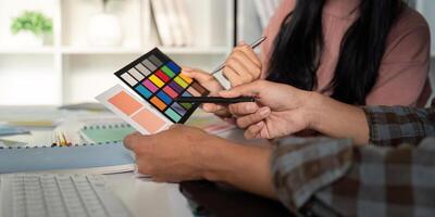 Diverse team evaluating color palettes for graphic design project. photo