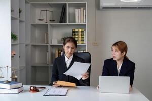 Lawyer reviewing documents while consulting with a client in a professional office. photo